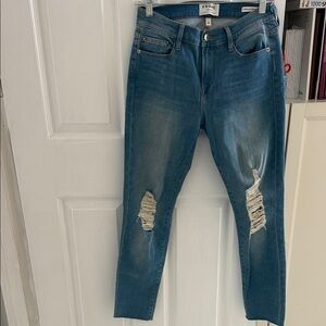 FRAME Le Skinny de Jeanne" featuring a light wash, distressed knees, raw hem.